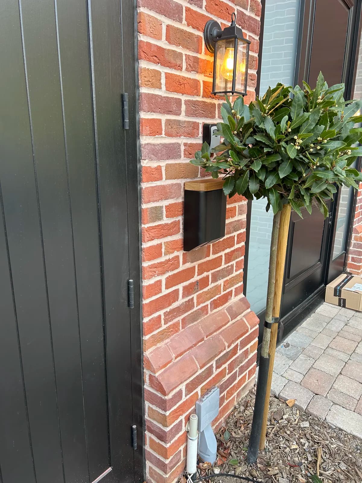 Home EV charger on a brick pier beside a front door